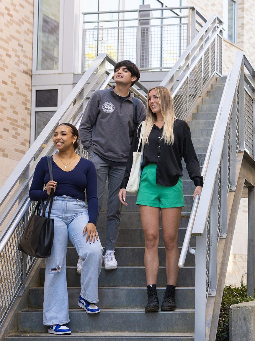 三名UWF学生走下校园户外楼梯.